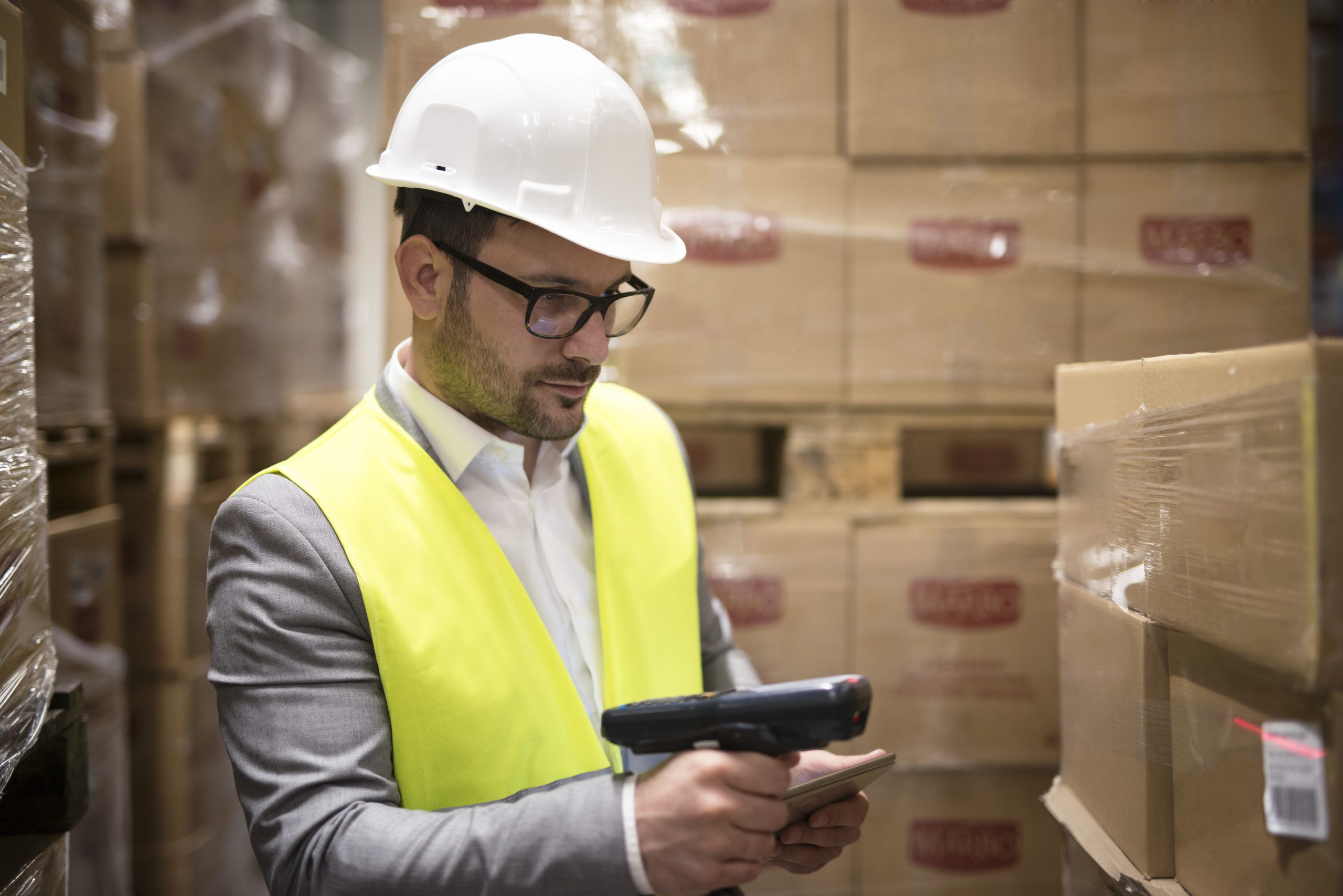 warehouse worker checking parcels with bar code reader